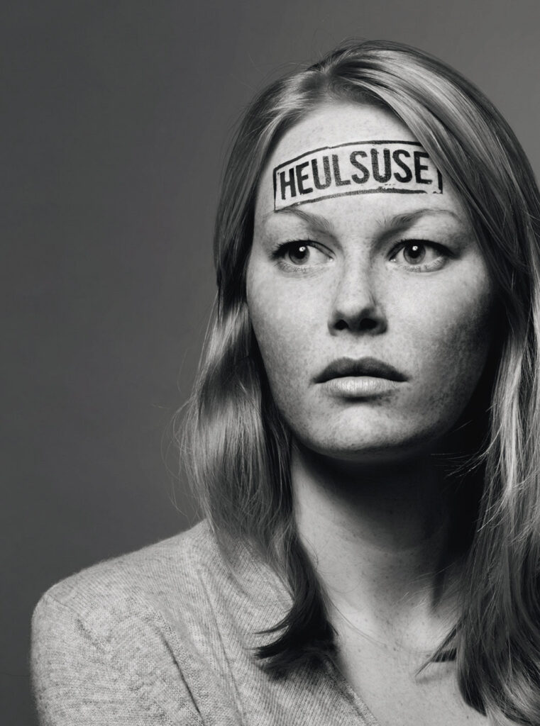 Schwarz-weiß Porträtbild einer Frau, auf ihrer Stirn ist der Schriftzug "Heulsuse"