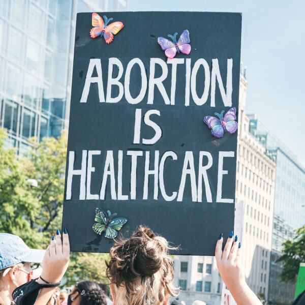 Demonstration, eine Person hält ein Schild mit dem Text "Abortion is healthcare"