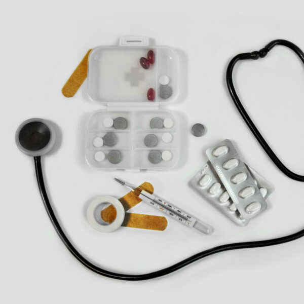 Medizinische Utensilien wie Stethoskop, Tabletten, Fiebermesser und Pflaster