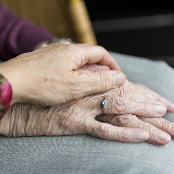 übereinanderliegende Hände von 2 älteren Menschen
