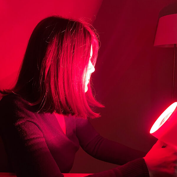 Brigitte Theißl sitzt vor einer Rotlichtlampe.