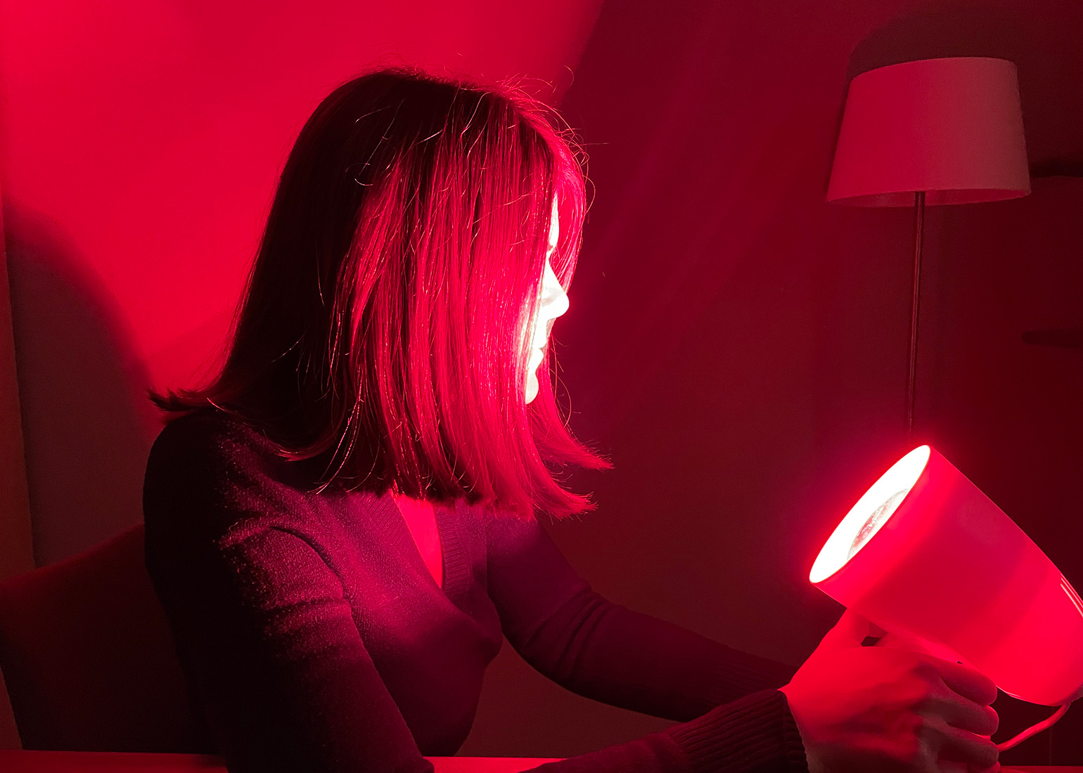 Brigitte Theißl sitzt vor einer Rotlichtlampe.