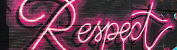 Wort "Respect" als neonpinkes Graffito auf einer Wand