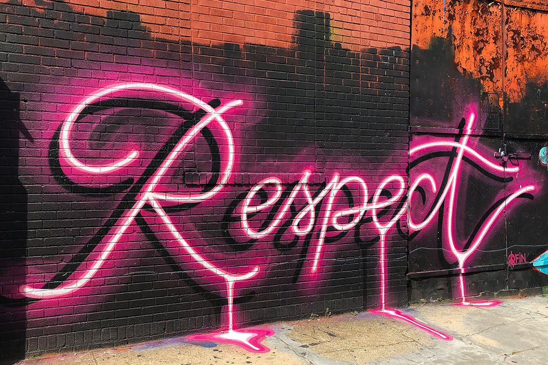 Wort "Respect" als neonpinkes Graffito auf einer Wand