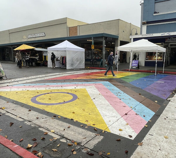 Große, auf eine Straße gemalte Progress Pride Flagge