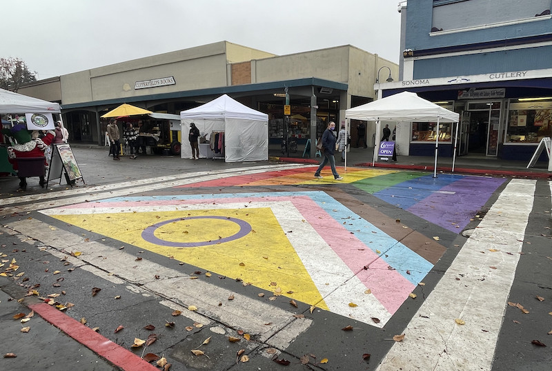 Große, auf eine Straße gemalte Progress Pride Flagge