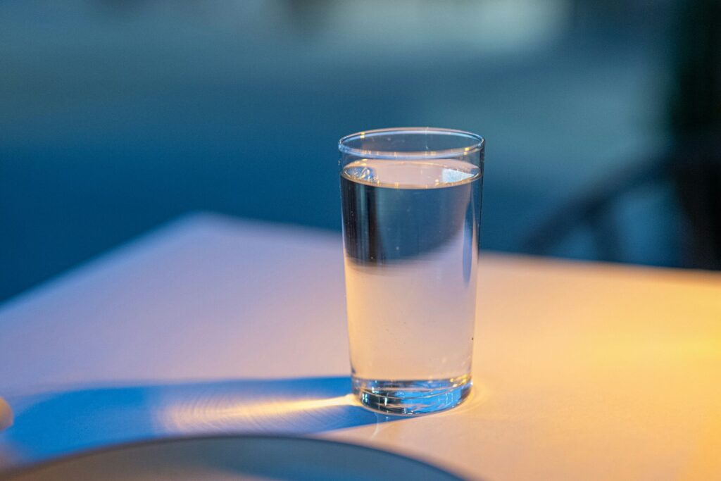 Ein volles Glas Wasser steht auf einem Tisch