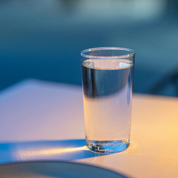 Ein volles Glas Wasser steht auf einem Tisch