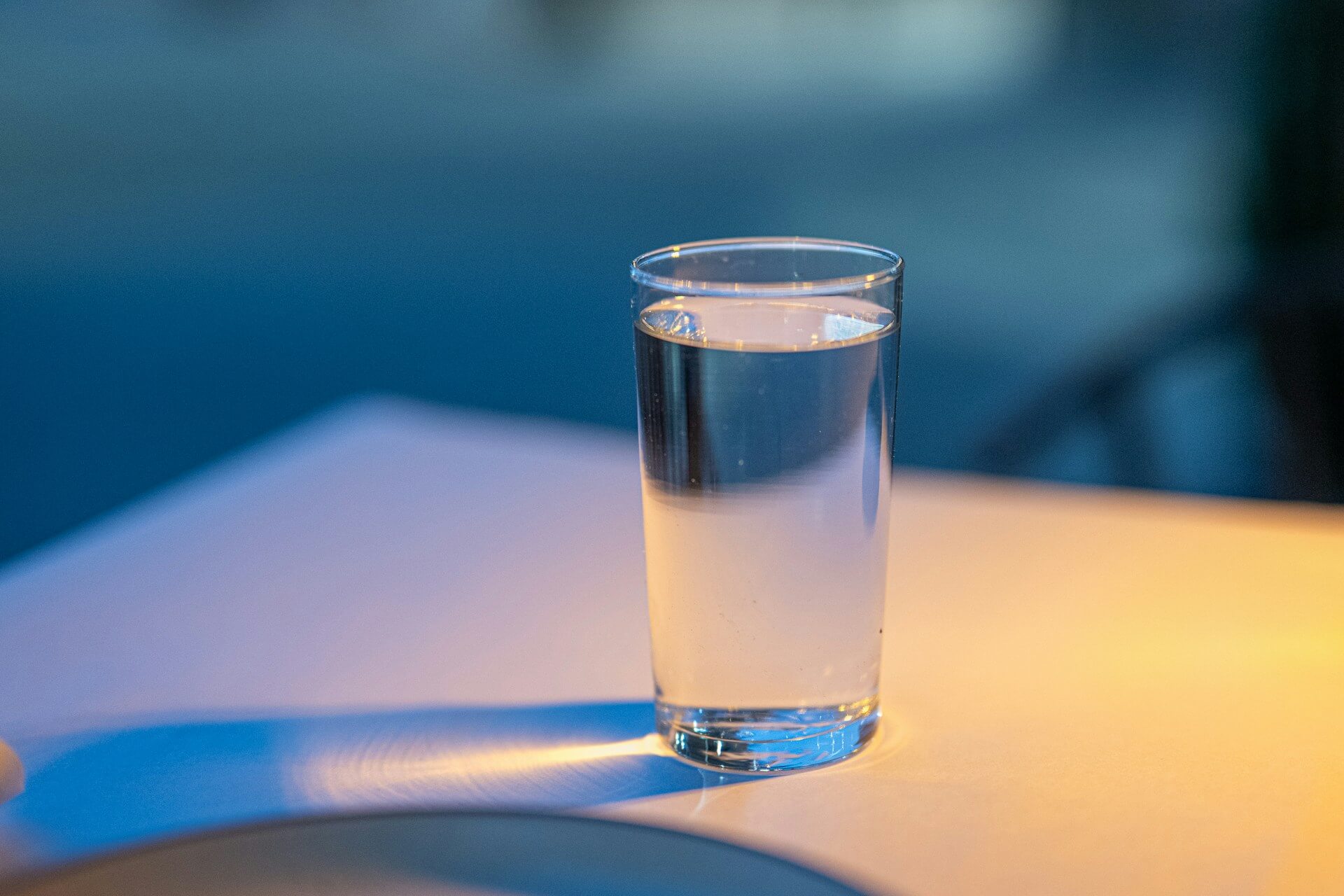 Ein volles Glas Wasser steht auf einem Tisch