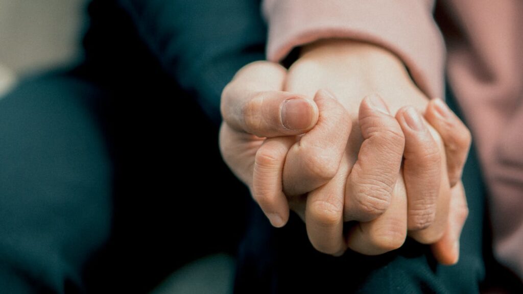 Zwei Personen halten sich an den Händen