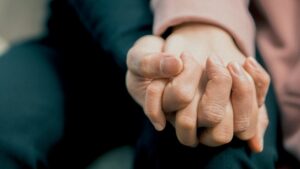 Zwei Personen halten sich an den Händen