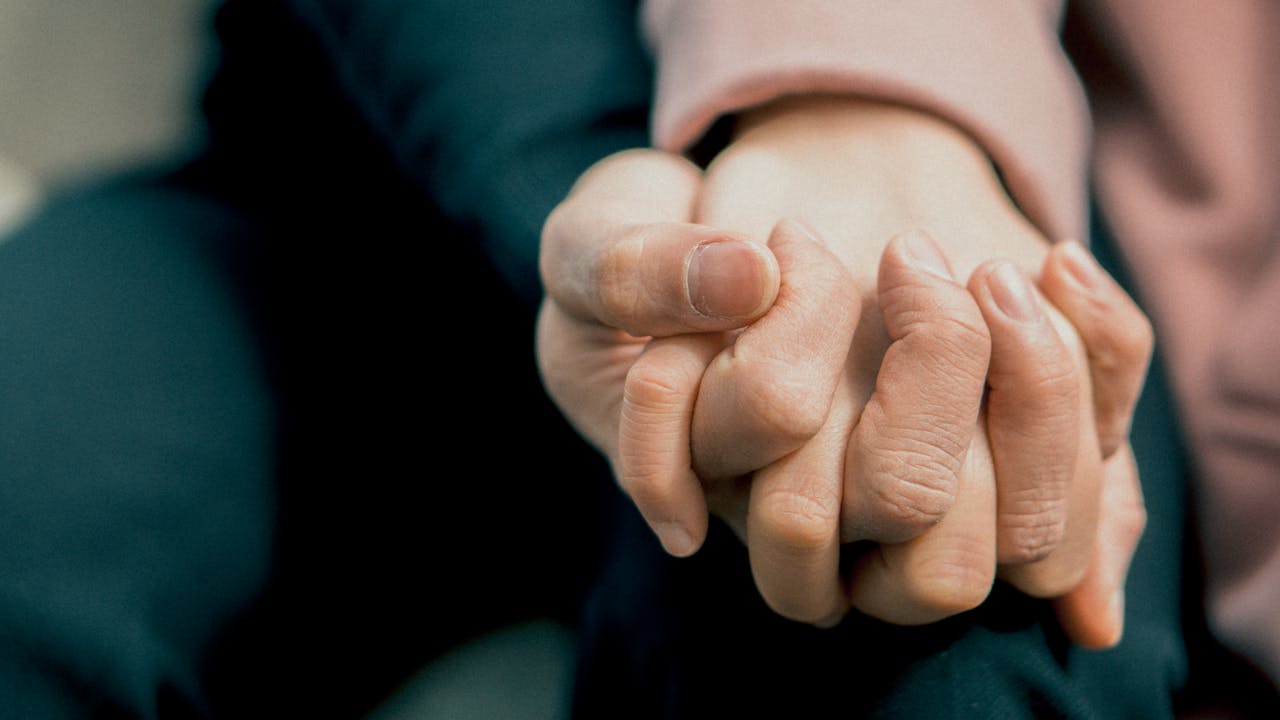 Zwei Personen halten sich an den Händen